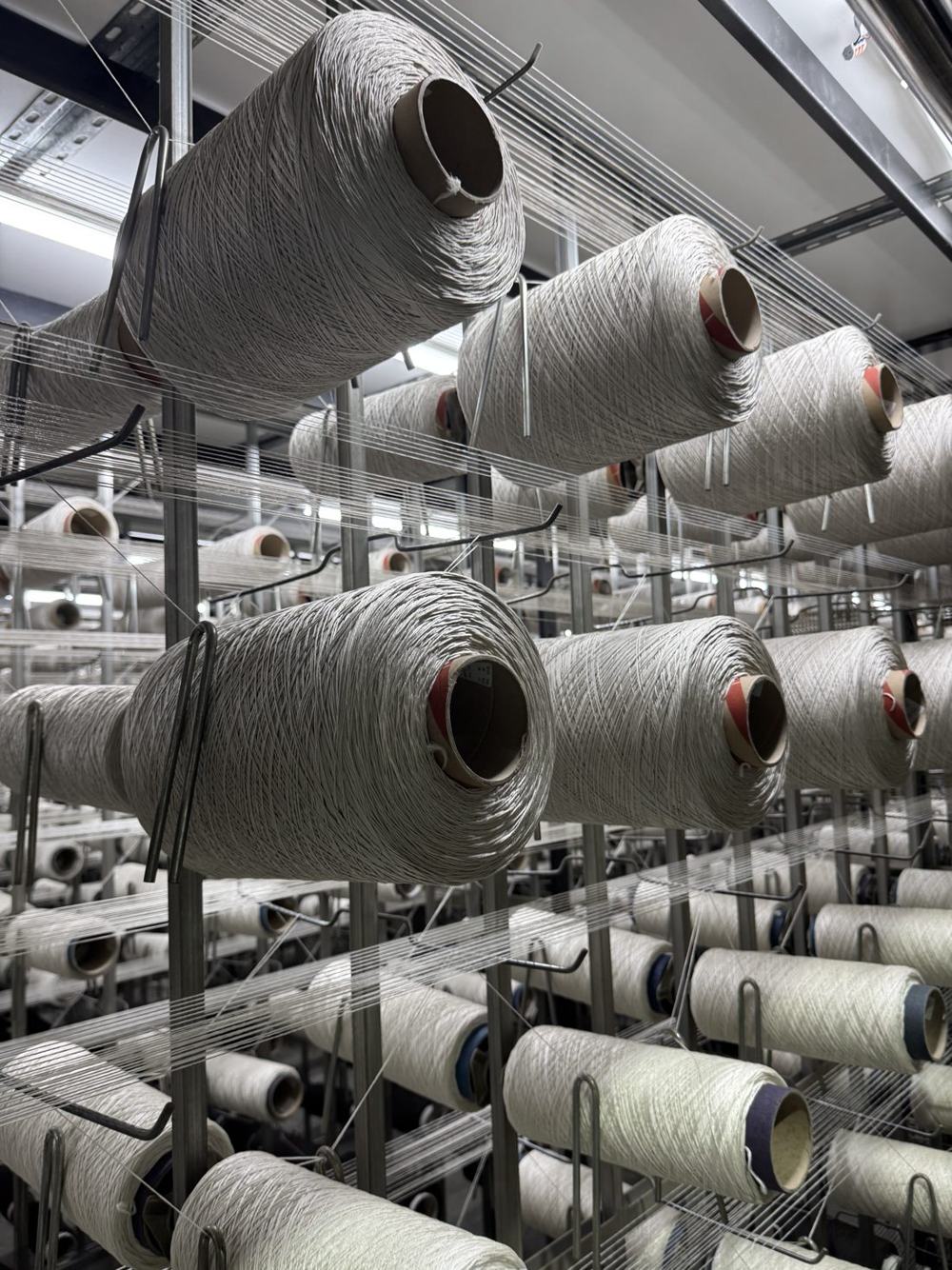 Cream polypropylene yarn cones on the twisting creel at Euro Yarns
